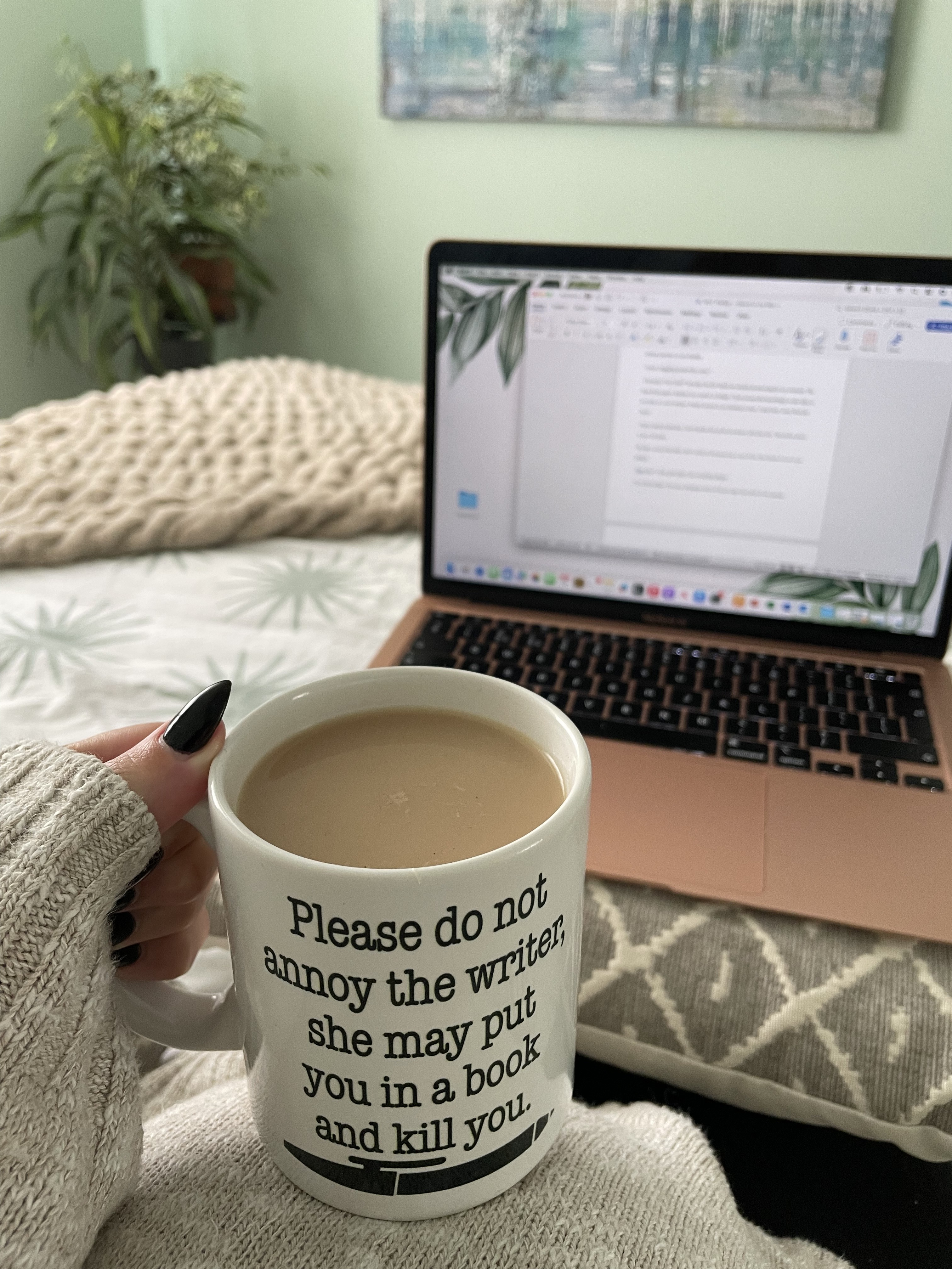 An image of someone holding a mug of coffee in front of an open word document